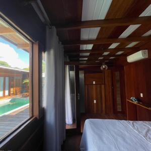 Chalés Mãe Natureza في فيرا كروز دو إيتاباريكا: غرفة نوم بسرير ونافذة كبيرة
