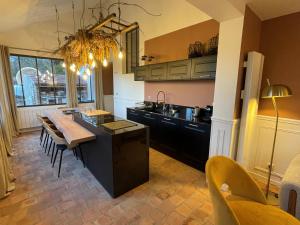 a kitchen with a table and a dining room at La Petite Maison de Giverny Chambres de charme Gîte 5 étoiles au Cœur du village in Giverny