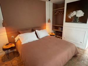um quarto com uma cama grande e 2 almofadas em La Petite Maison de Giverny Chambres de charme Gîte 5 étoiles au Cœur du village em Giverny