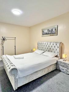a bedroom with a large bed with white sheets at Full Home in Heywood Street near Cheetham Hill in Manchester