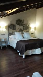ein Schlafzimmer mit einem großen weißen Bett mit zwei Lampen in der Unterkunft Casa Rural Manuel de Pepa Xuaca in Tuilla