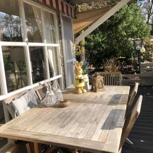 - une table en bois sur la terrasse couverte d'une maison dans l'établissement Chalet 2Relax, à Zutendaal