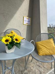 una mesa con un jarrón de girasoles y una almohada amarilla en Casa civico22, en Fratta Todina