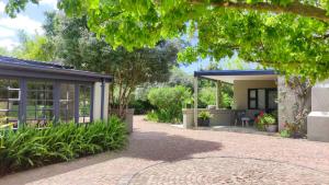 a house with a patio and a garden at Blissful Country Garden King Bed Cottage in Grabouw