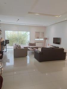 a large living room with couches and a tv at Amazing villa next to the beach in Nabeul