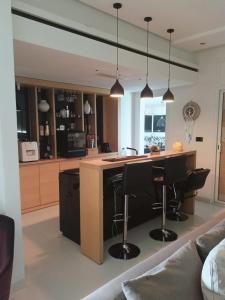 a kitchen with a island with black bar stools at Amazing villa next to the beach in Nabeul