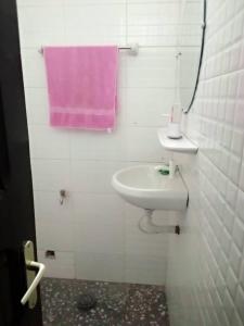 uma casa de banho com um lavatório e uma toalha cor-de-rosa em HOME OF KINGS AND QUEENS em Porto-Novo