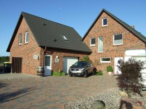 a brick house with a car parked in front of it at Elbe19 Ferienwohnung in Marschacht