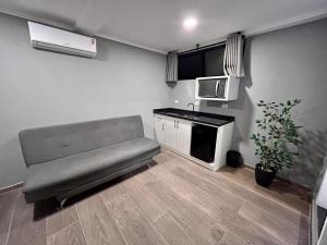 uma pequena cozinha com um sofá num quarto em Terrazas Hotel em Curitiba