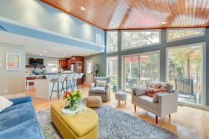 an open living room with a blue couch and chairs at Cheerful Lake Wylie Home with Fire Pit! in Charlotte