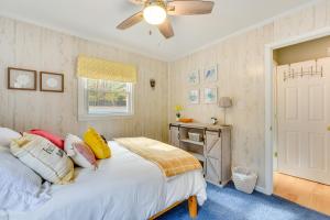 a bedroom with a bed with a ceiling fan and a desk at Cheerful Lake Wylie Home with Fire Pit! in Charlotte