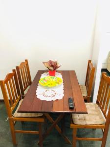 a wooden table with a plate of food on it at Apartamento Aconchegante - Boraceia (Bertioga) in Bertioga