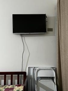 telewizor z płaskim ekranem wiszący na ścianie w obiekcie Apartamento Aconchegante - Boraceia (Bertioga) w mieście Bertioga
