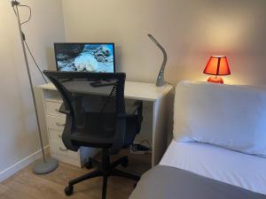 a bedroom with a desk with a computer and a bed at chambre double std in Longjumeau
