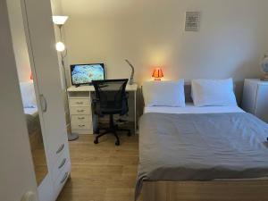a bedroom with a bed and a desk with a computer at chambre double std in Longjumeau