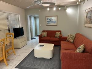 a living room with two couches and a tv at Treasure Island Beach Club 727-360-7096 in St Pete Beach