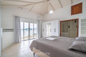 ein Schlafzimmer mit einem Bett und einem großen Fenster in der Unterkunft Casa de luxo com vista para o mar, Itapema CDP025 in Itapema