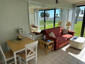 a living room with a red couch and a table at Treasure Island Beach Club 727-360-7096 in St Pete Beach