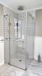 a bathroom with a shower with a glass door at Blissful Country Garden Self-Catering Cottage in Grabouw