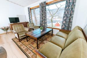 a living room with a couch and chairs and a table at Hjelmeland Camping & Hostel Nøkling in Hjelmeland