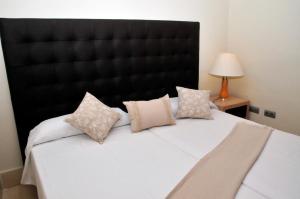 a bedroom with a large bed with a black headboard at LAS MAREAS in Tazacorte +28 photos