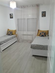 una camera con due letti e una finestra di Sweet 2 rooms accommodation a Birkhadem
