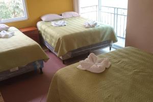 een hotelkamer met 2 bedden en handdoeken erop bij Casa 4 a 5 minutos del IRTRA in Retalhuleu