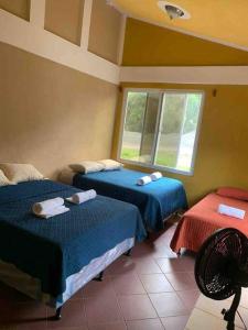 a room with two beds and a window at Casa 4 a 5 minutos del IRTRA in Retalhuleu