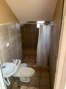 a small bathroom with a toilet and a sink at Casa 4 a 5 minutos del IRTRA in Retalhuleu