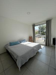 ein Schlafzimmer mit einem Bett und einem großen Fenster in der Unterkunft departamento céntrico y moderno in Gualeguaychú