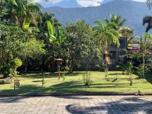 a courtyard with trees and a building with a mountain at Casas CostaMar in Caraguatatuba