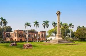 a monument in front of an old building with palm trees at THE ROYAL PRESIDENCY INN in Lucknow