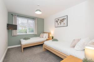 een slaapkamer met 2 bedden en een raam bij Stylish & Modern 2 Bed 2 Bath With Free Parking in Leeds