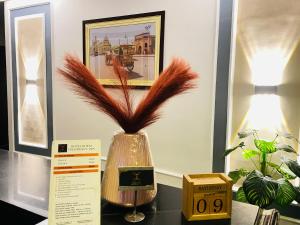 a vase with feathers in it sitting on a table at THE ROYAL PRESIDENCY INN in Lucknow