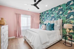 a bedroom with a large bed with a tropical wallpaper at New - Home Sweet Houston in Houston