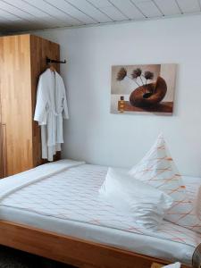 a bedroom with a bed and a robe hanging on a wall at Pension Forstgut Waldeck in Ingelheim am Rhein