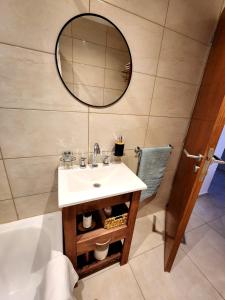 een badkamer met een wastafel, een spiegel en een bad bij Golden Home in La Plata
