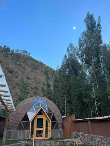 a building with a window on the side of a mountain at Domos lujosos, completos y privados en Cusco in Calca