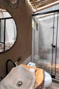 a bathroom with a sink and a toilet and a mirror at Domos lujosos, completos y privados en Cusco in Calca