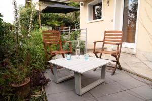 2 stoelen en een witte tafel op een patio bij Charmant Appartement T2 Parking & Terrasse - Crêt de la Roche in Aix-les-Bains
