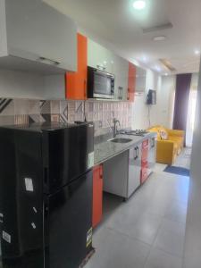 eine Küche mit einer Spüle und einem schwarzen Kühlschrank in der Unterkunft بورتو مطروح الهاني in Marsa Matruh