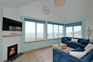 Cliff Top Cottage with Sea Views في Portknockie: غرفة معيشة مع أريكة زرقاء ومدفأة