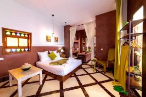 ein Schlafzimmer mit einem Bett und einem Tisch in einem Zimmer in der Unterkunft Riad Ambre et Jasmin in Marrakesch