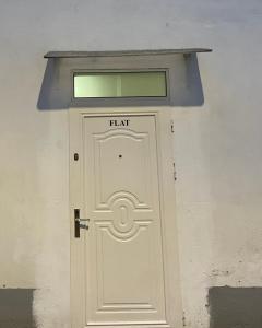 une porte blanche avec une fenêtre au-dessus de celle-ci dans l'établissement Flat, à Tirana