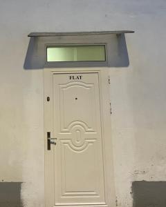 a white door with a window above it at Flat in Tirana