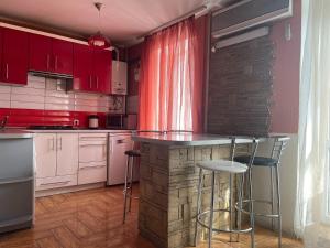 聶伯城的住宿－Гагарина Нагорка 2 кв，一间厨房,配有白色橱柜和一个带凳子的酒吧
