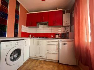 聶伯城的住宿－Гагарина Нагорка 2 кв，厨房配有洗衣机和红色橱柜。