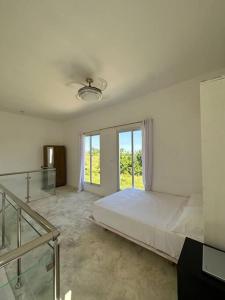 - une chambre blanche avec un lit et un escalier en verre dans l'établissement Casita Yanella, à Cabrera