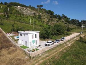 una vista aerea di una casa bianca con auto parcheggiate di Casita Yanella a Cabrera