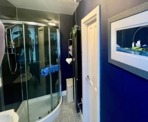 a bathroom with a shower and a blue wall at The Lodge Dunrowan in Kyle of Lochalsh +53 photos